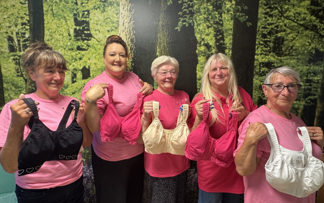 four ladies holding up bras