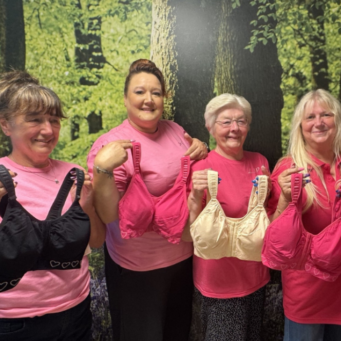 The Pink Ladies group holding up new bras