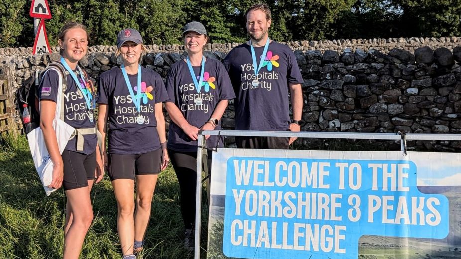 4 people standing by the welcome sign for the Yorkshire Peaks Challenge 