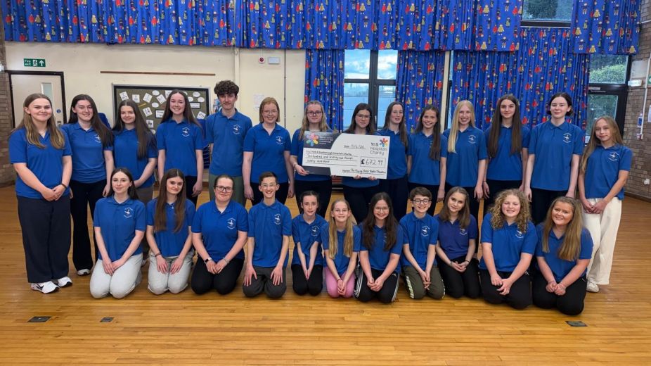 Haxby youth theatre club standing for a group picture holding a giant cheque