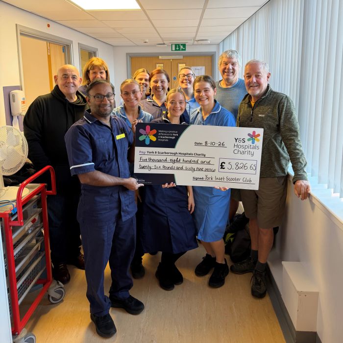nursing staff and fundraisers gathered together holding a giant cheque 