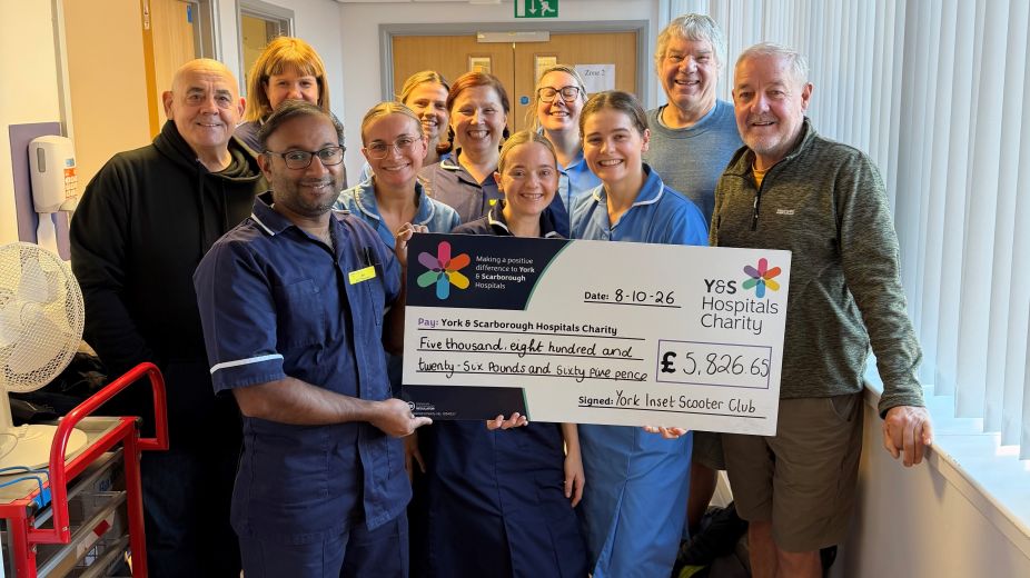nursing staff and fundraisers gathered together holding a giant cheque 