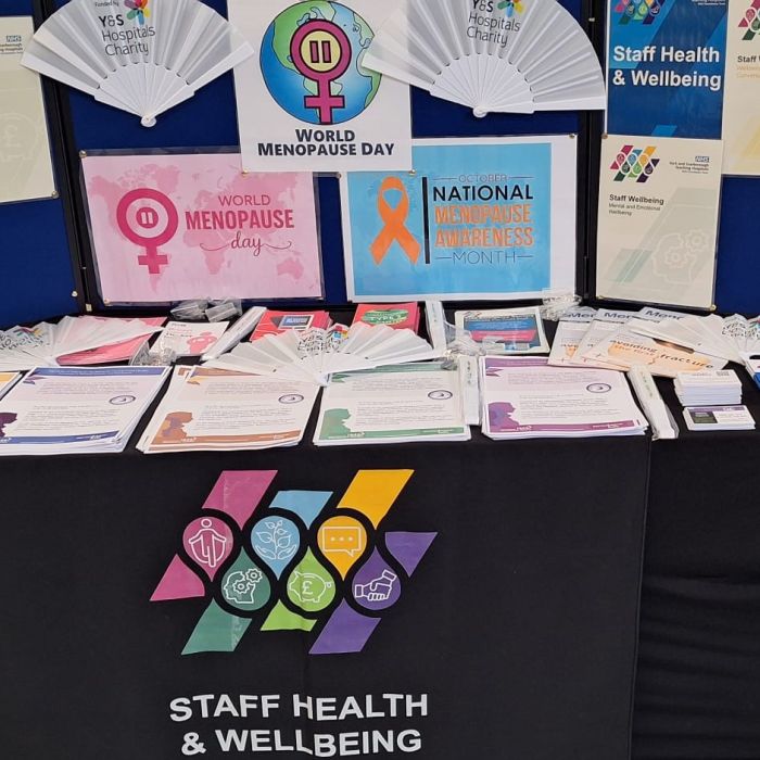 stall displaying fans with charity logos and other benefits information 