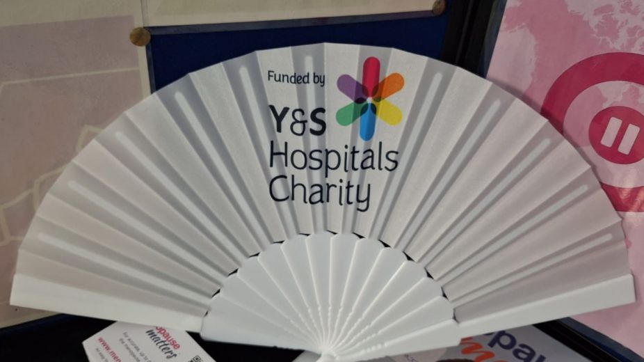 stall displaying fans with charity logos and other benefits information 