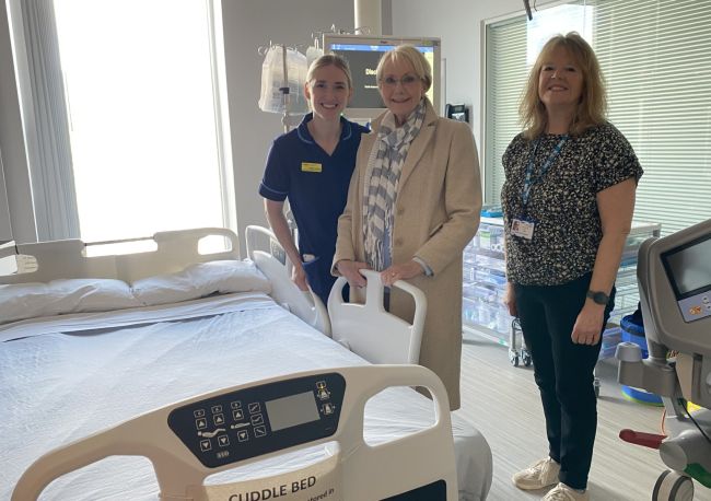 fundraiser and palliative care team members with cuddle bed