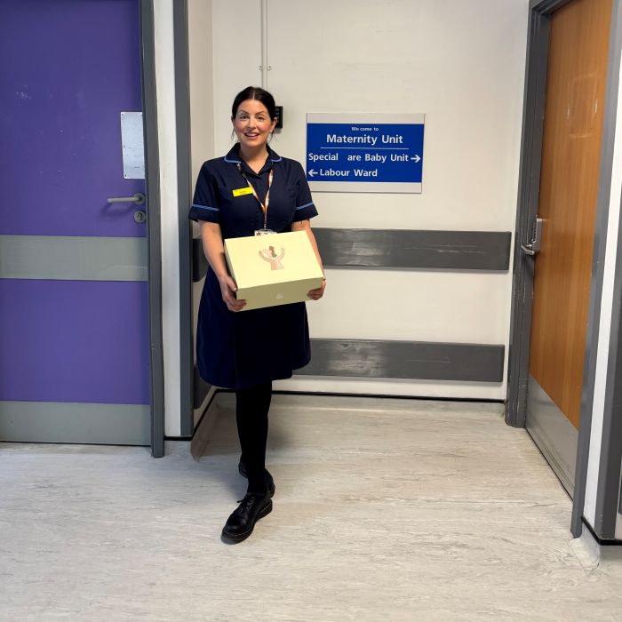 Nurse holding a HOPE box with gifts in for mum and baby