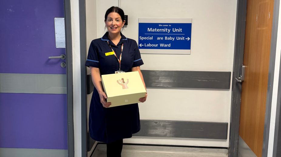 Nurse holding a HOPE box with gifts in for mum and baby