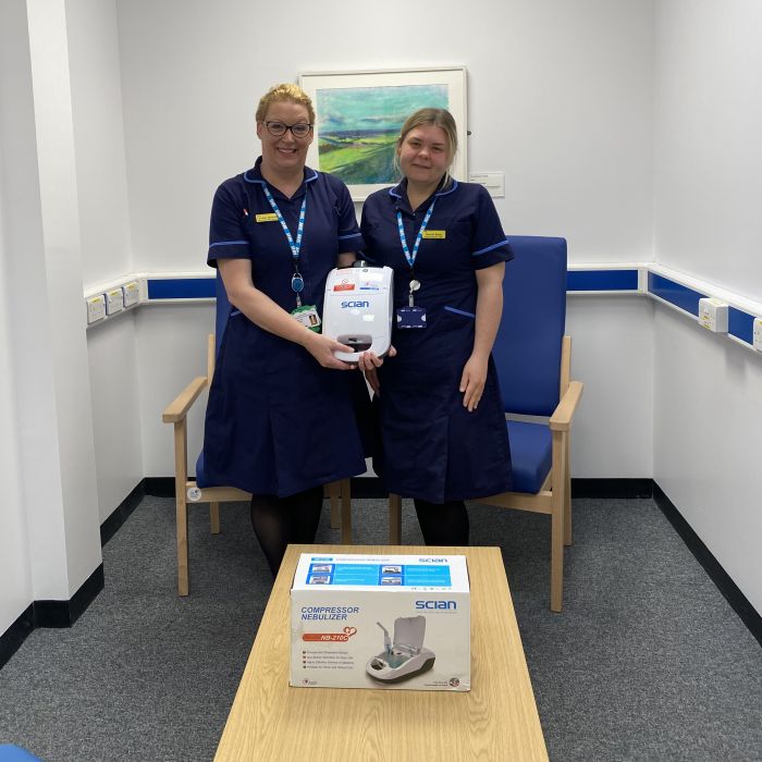 two nurses in uniform holding nebuliser equipment