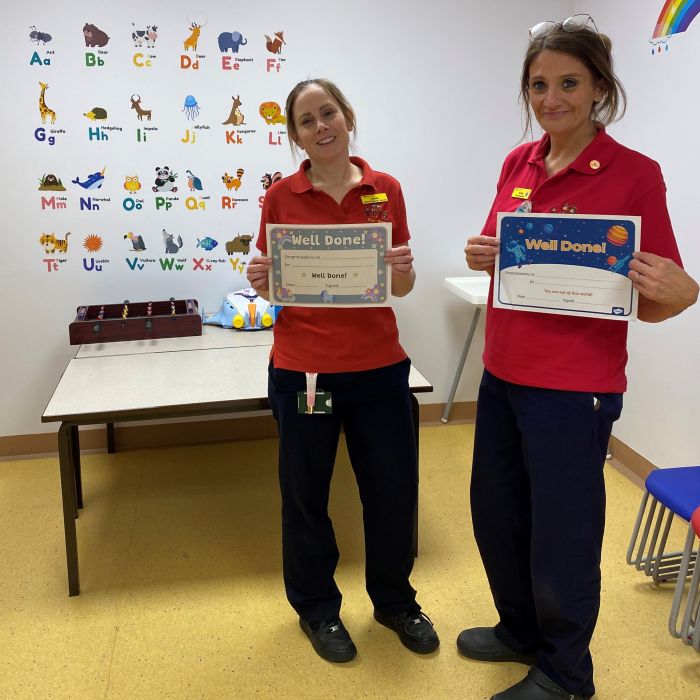 2 ladies holding children certificates