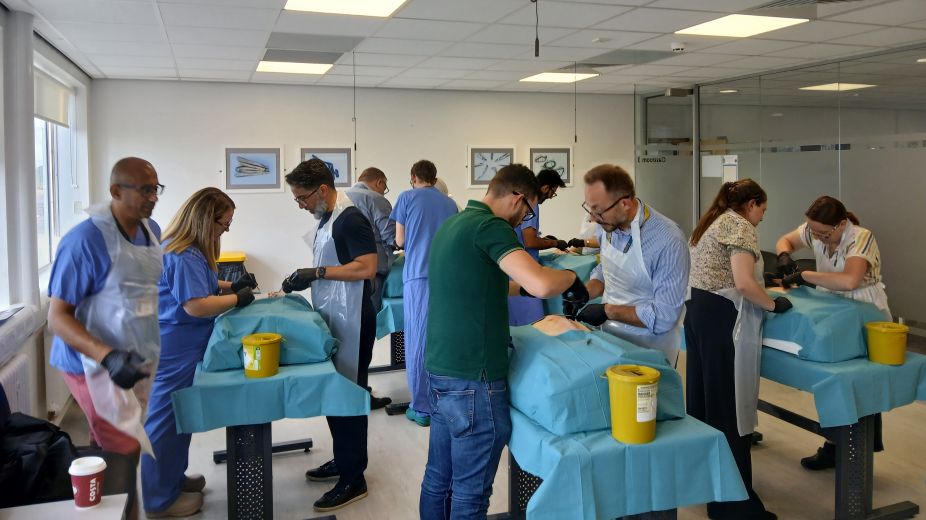 surgeons practicing incisions on silicone belly